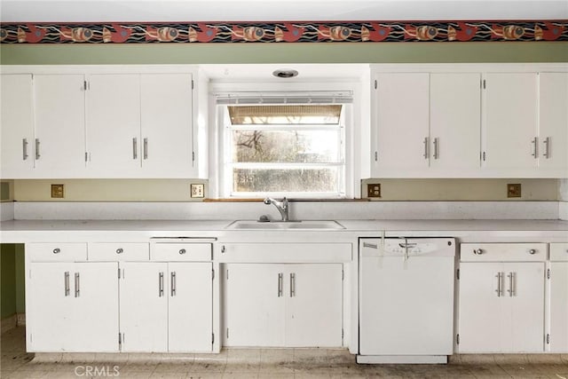 kitchen featuring light countertops, white cabinetry, dishwasher, and a sink