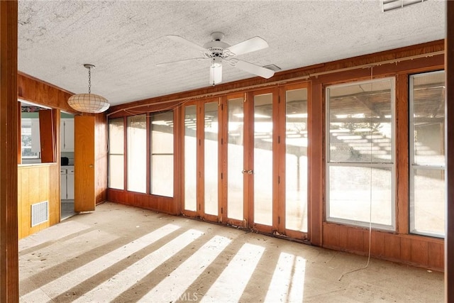 unfurnished sunroom featuring visible vents and a ceiling fan