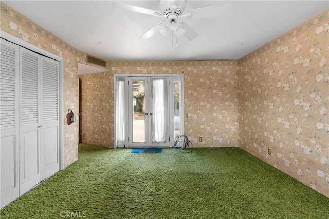 unfurnished room with visible vents, ceiling fan, carpet flooring, and wallpapered walls