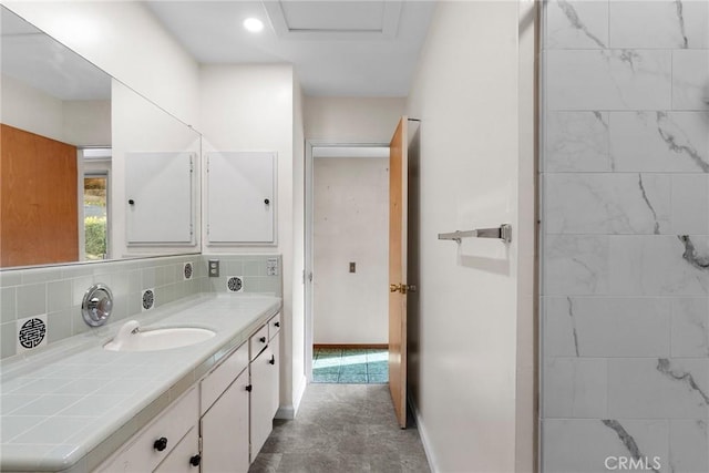 bathroom with recessed lighting, baseboards, vanity, and decorative backsplash