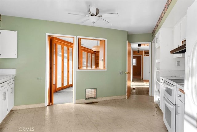 kitchen with visible vents, a ceiling fan, white cabinets, double oven range, and under cabinet range hood