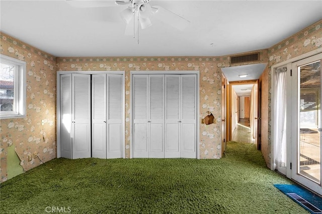 unfurnished bedroom featuring wallpapered walls and visible vents