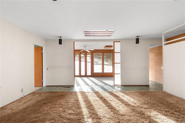 empty room featuring a ceiling fan and carpet