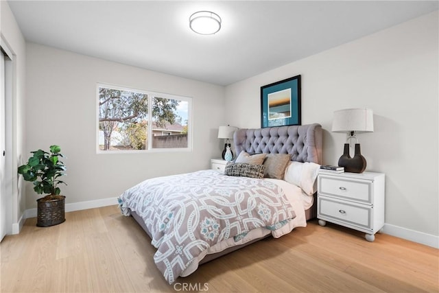 bedroom featuring light wood-style floors and baseboards