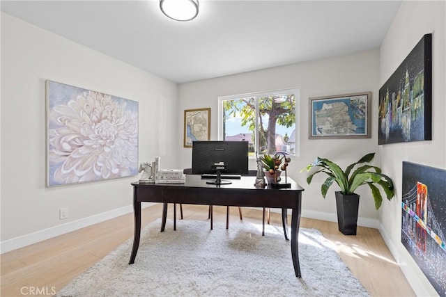 office space with baseboards and wood finished floors