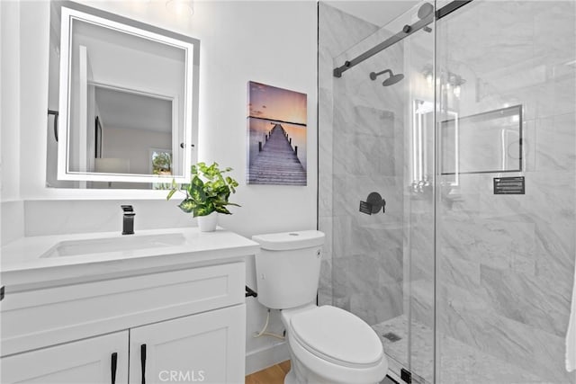 full bathroom featuring vanity, toilet, and a marble finish shower