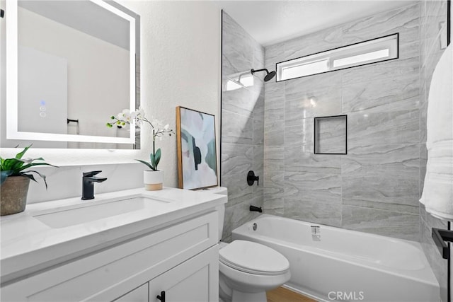 bathroom featuring shower / bathing tub combination, toilet, vanity, and a textured wall