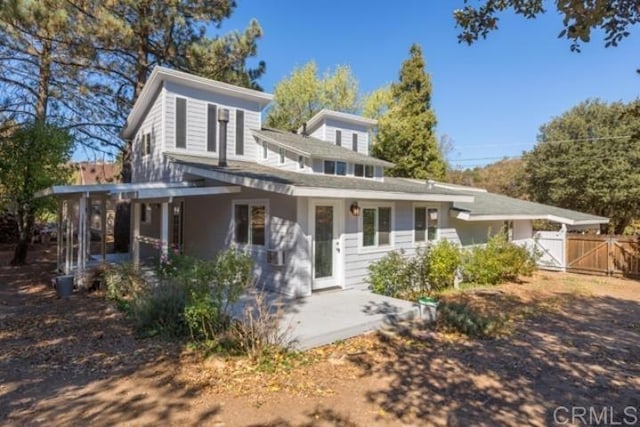 view of front of home with a patio, fence, and a gate