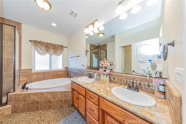 full bath with a garden tub, double vanity, a stall shower, and a sink