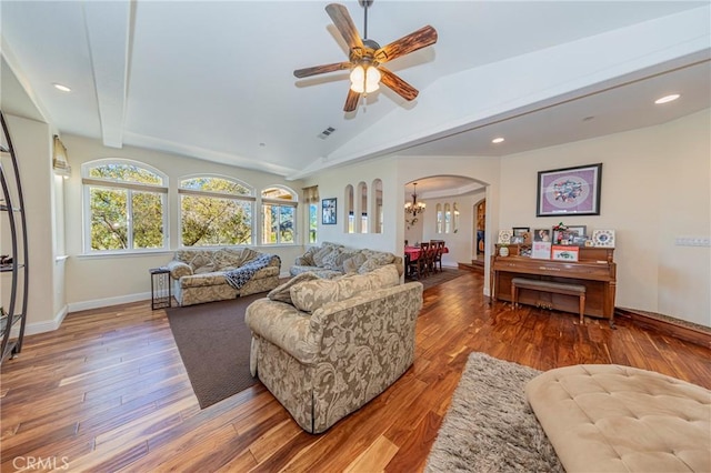 living room featuring arched walkways, lofted ceiling with beams, wood finished floors, and visible vents