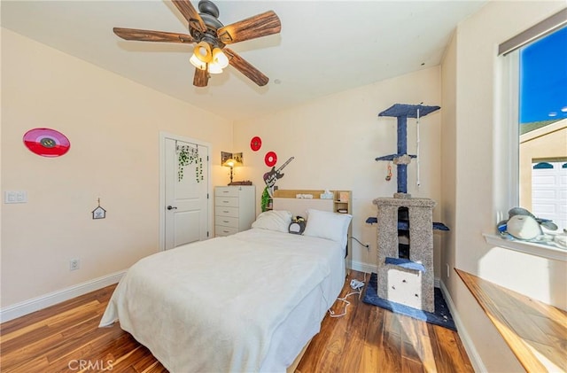 bedroom featuring ceiling fan, baseboards, and wood finished floors