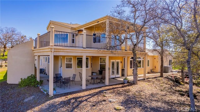 back of property featuring french doors, a patio area, and stucco siding