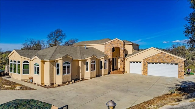 view of front of property featuring a garage, stone siding, concrete driveway, and stucco siding