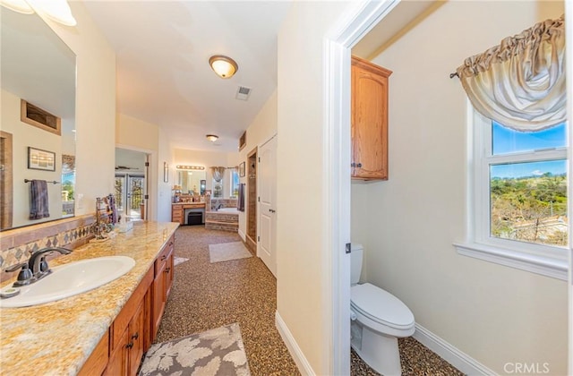 full bath with a wealth of natural light, visible vents, vanity, and toilet