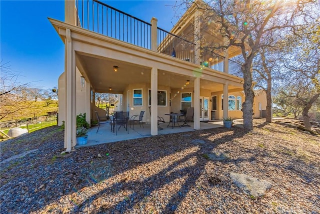 back of property featuring a patio area and a balcony