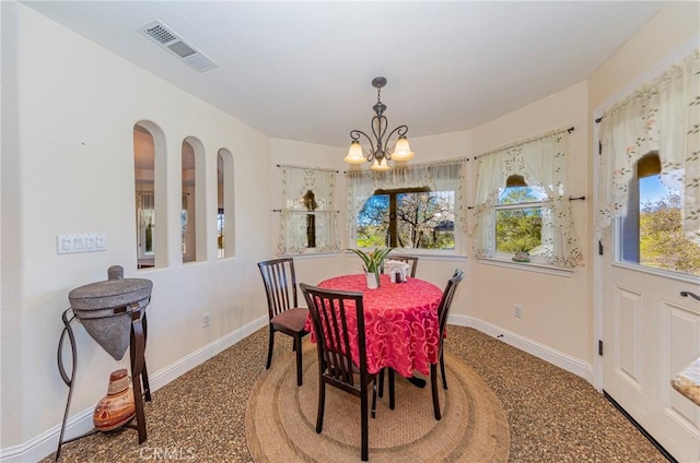 dining space with a chandelier, visible vents, and baseboards