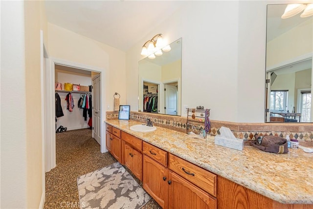 bathroom featuring a walk in closet and vanity