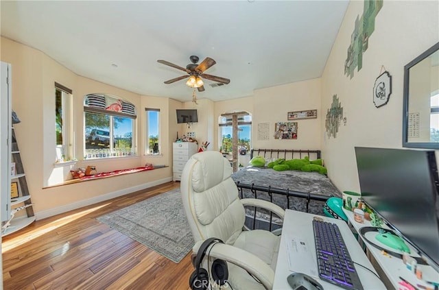 office area with ceiling fan, baseboards, and wood finished floors