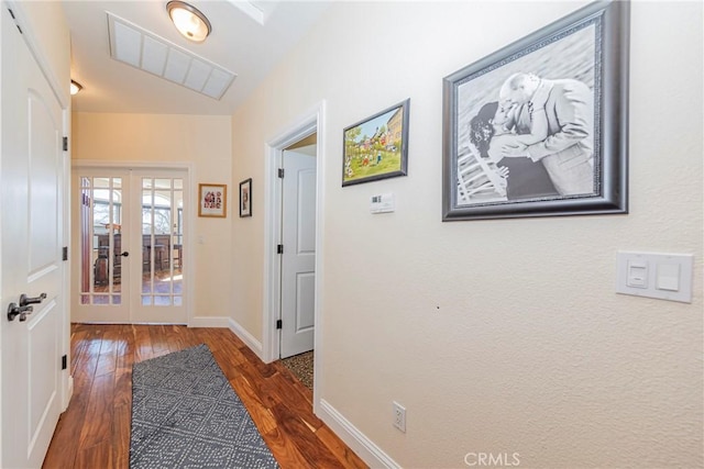 corridor with french doors, wood finished floors, visible vents, and baseboards