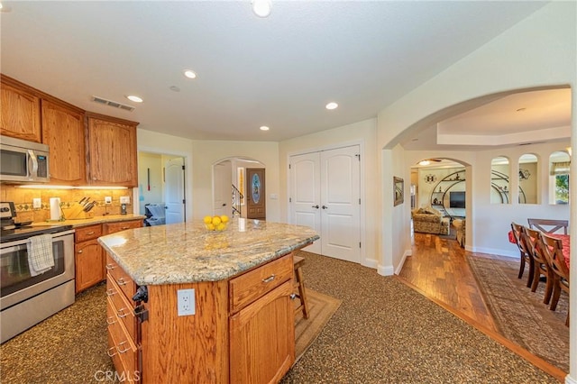 kitchen featuring tasteful backsplash, visible vents, light stone countertops, stainless steel appliances, and recessed lighting