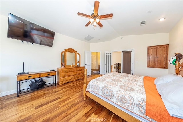 bedroom featuring light wood finished floors, visible vents, a ceiling fan, vaulted ceiling, and baseboards