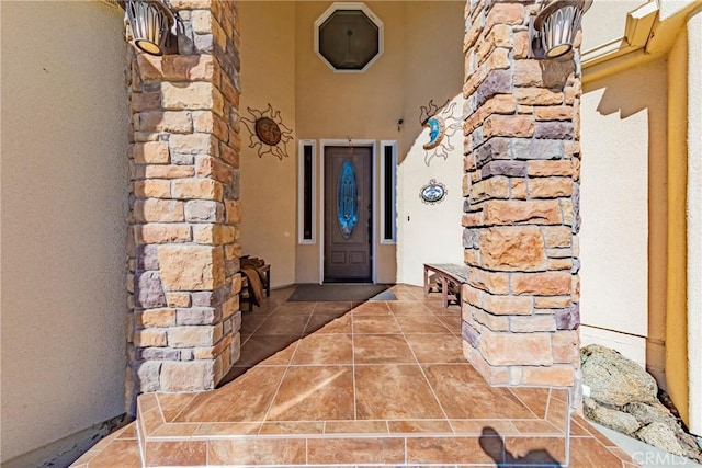 doorway to property featuring stone siding and stucco siding