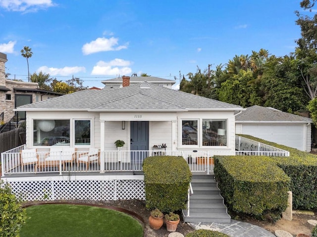 bungalow-style home with covered porch and roof with shingles