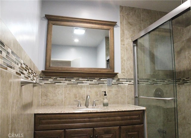 full bathroom with a stall shower, decorative backsplash, and vanity