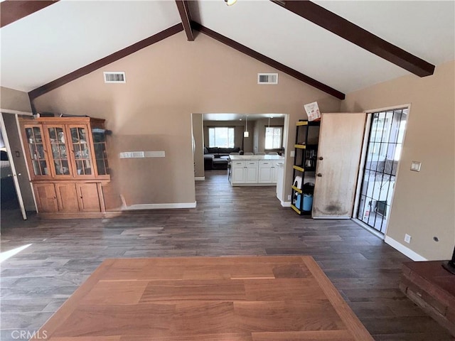 interior space featuring dark wood-style flooring, visible vents, beamed ceiling, and a healthy amount of sunlight