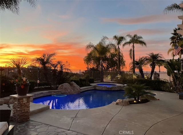 pool at dusk featuring a fenced in pool, a patio area, a fenced backyard, and an in ground hot tub