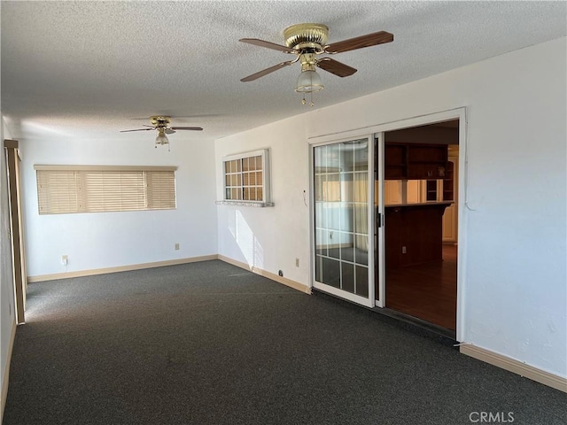 empty room with baseboards, a ceiling fan, and a textured ceiling