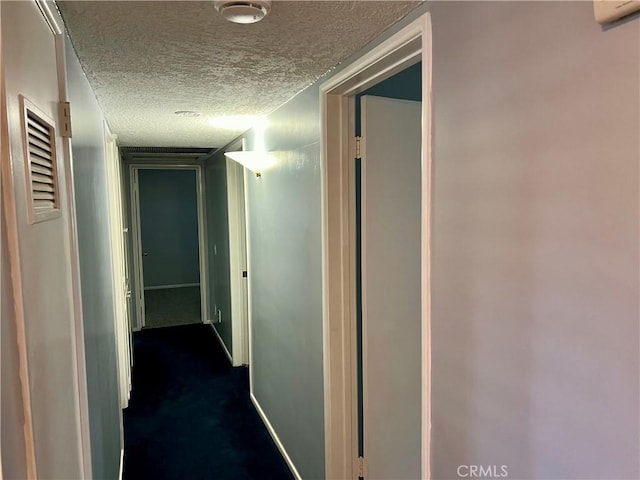 corridor with baseboards and a textured ceiling