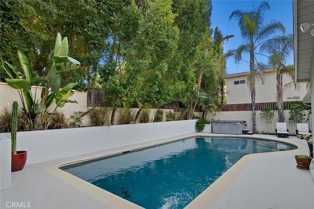 view of swimming pool featuring a fenced in pool, a fenced backyard, a patio, and a hot tub