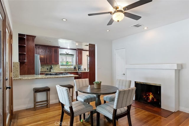 4816 Atoll Ave, Sherman Oaks, CA 91423 - dining area featuring light wood-style flooring, a ceiling fan, a lit fireplace, and recessed lighting