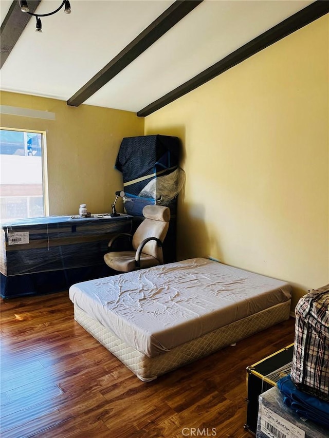 bedroom featuring beam ceiling and wood finished floors