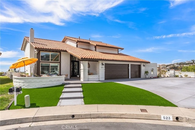 mediterranean / spanish house with a garage, a front lawn, and a tile roof