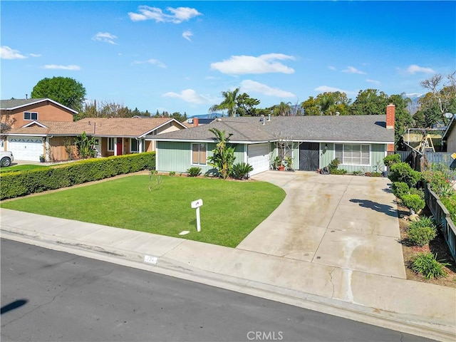 ranch-style home featuring a garage, concrete driveway, fence, and a front lawn