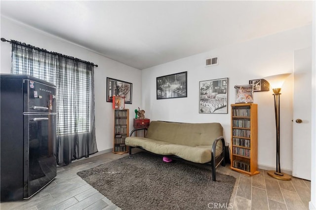 sitting room with visible vents and wood finished floors