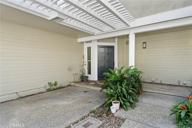 entrance to property featuring a patio and a pergola