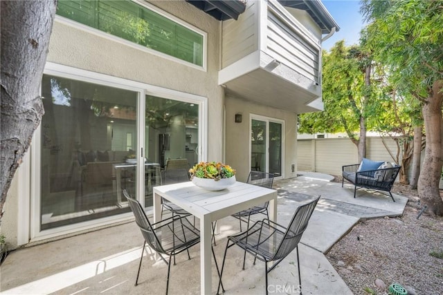 view of patio featuring outdoor dining area and fence