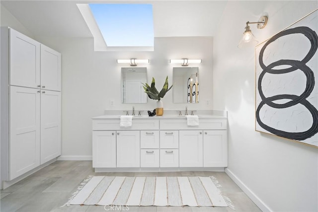 full bathroom featuring double vanity, baseboards, and a sink