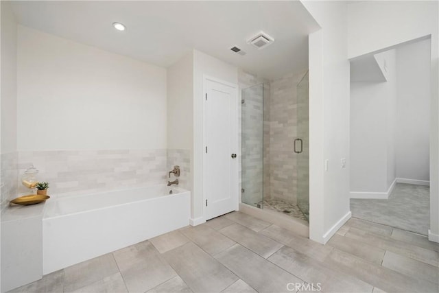 bathroom with visible vents, a stall shower, a bath, and baseboards