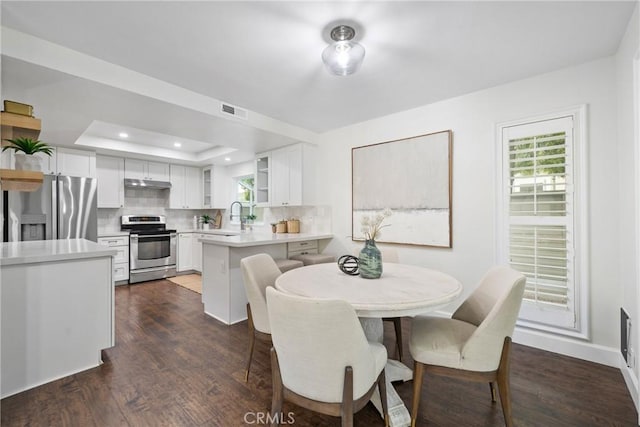 dining area with baseboards, visible vents, a raised ceiling, dark wood-style flooring, and recessed lighting