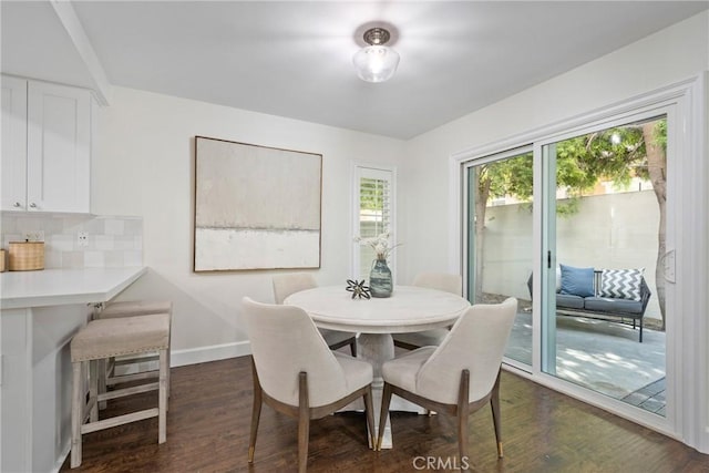 dining area featuring dark wood-style floors and baseboards