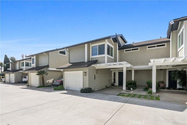 multi unit property with a garage, driveway, and a pergola