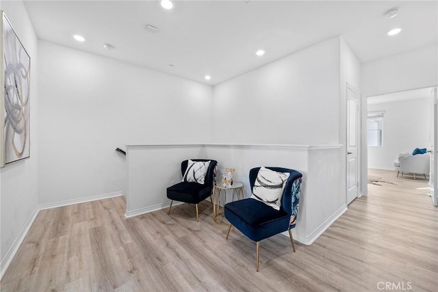 living area with baseboards, wood finished floors, and recessed lighting