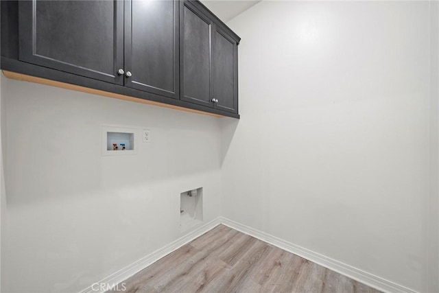 laundry area with light wood finished floors, hookup for a washing machine, cabinet space, and baseboards