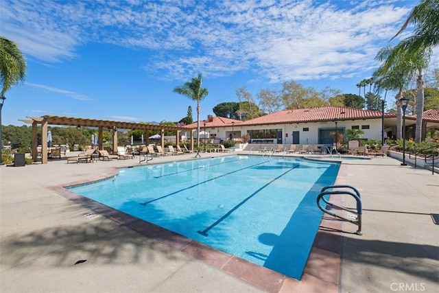 community pool with a patio area and a pergola