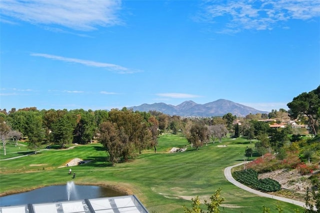 view of community featuring a water and mountain view, golf course view, and a lawn