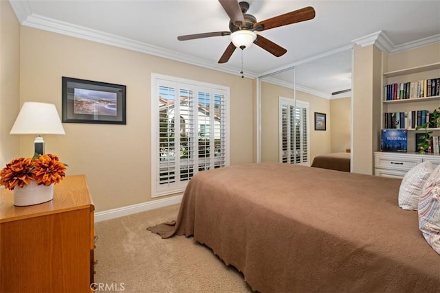 bedroom featuring crown molding, a closet, light colored carpet, ceiling fan, and baseboards